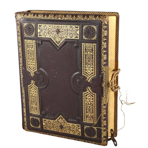 134 - A Victorian gilded leather-bound photograph album, with musical movement, 30cm x 23cm