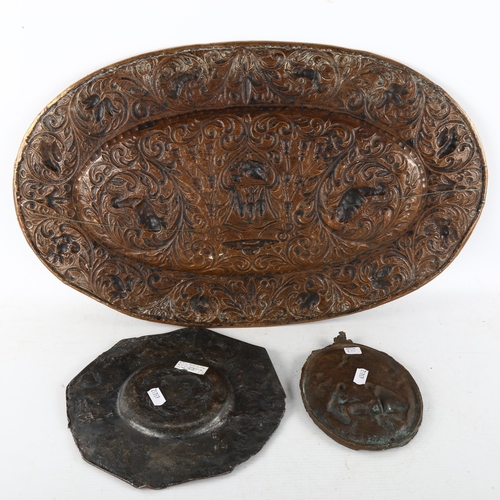 140 - An oval copper armorial plaque, length 52cm, and 2 relief cast bronze plaques (3)