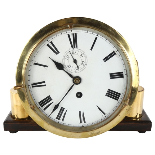 4 - An Antique brass ship's bulkhead clock, white enamel dial with Roman numeral hour markers and subsid... 