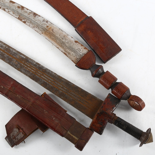 62 - An antique Saharan Takouba sword in leather scabbard, and another North African short sword, longest... 