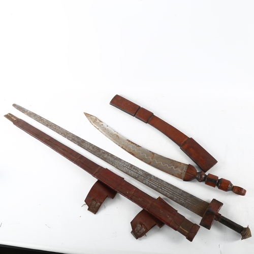 62 - An antique Saharan Takouba sword in leather scabbard, and another North African short sword, longest... 