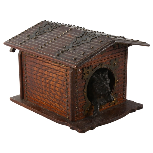 80 - A stained wood cigar box in the form of a dog kennel, with patinated metal dog and brass strapwork h... 