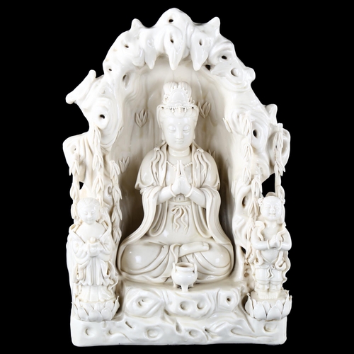 97 - A Chinese blanc de chine porcelain figure of Buddha in a cave flanked by attendant figures, impresse... 