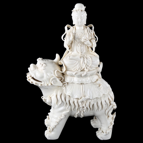 98 - A Chinese blanc de chine porcelain figure of Buddha riding a Dog of Fo, impressed seal marks on reve... 