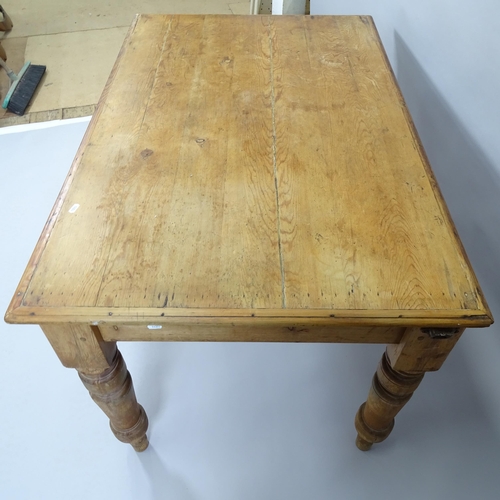 2003 - An antique pine farmhouse kitchen table with two fitted drawers, raised on turned legs. 125x76x80cm