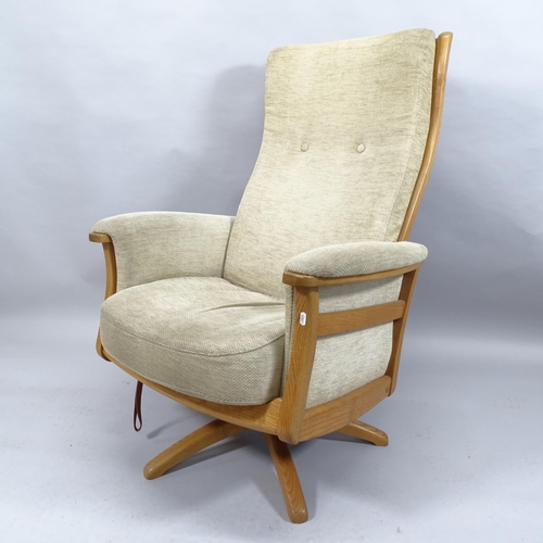 2022 - A mid-century Ercol Gina swivel reclining lounge chair, with ash frame, upholstered cushions and mak... 