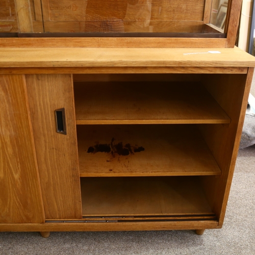 169 - A mid-century oak library display / bookcase, with glass shelving and sides to top, and cupboard und... 