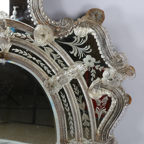 102 - A Venetian wall mirror with elaborate moulded flowerhead mounts and etched panels, overall height 11... 