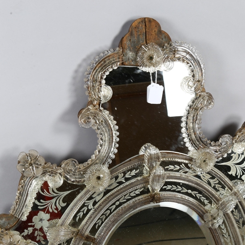 102 - A Venetian wall mirror with elaborate moulded flowerhead mounts and etched panels, overall height 11... 