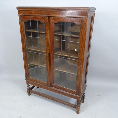 2034 - An antique oak bookcase, with two leadlight glazed doors and three adjustable shelves. 92x135x29cm