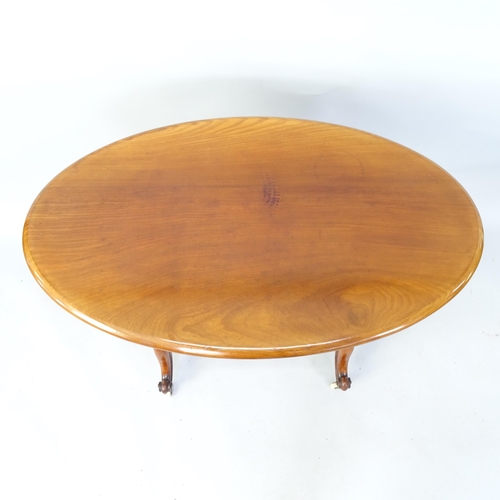 2090 - A Victorian Mahogany oval cantre table with fluted columns and turned stretcher, 94cm x 76cm x 57cm