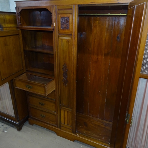 2095 - An Arts and Crafts oak Beaconsfield wardrobe in four sections, with single mirrored door, a panelled... 