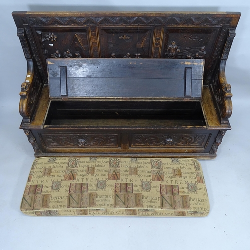 2107 - An antique oak settle with carved decoration and liftin seat. 158cm x 107cm x 54cm