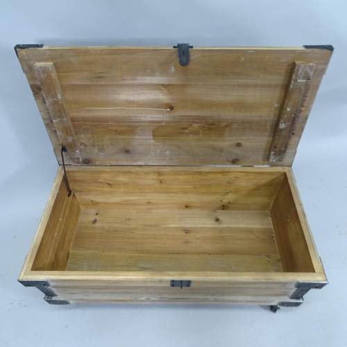 2128 - A contemporary pine storage box / low coffee table with lifting lid, raised on casters. 83cm x 33cm ... 