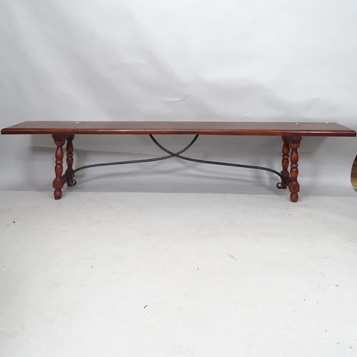 2131 - A mahogany bench with cast iron stretcher, having hinged legs. 215cm x 48cm x 31cm. Impressed 4400 3... 