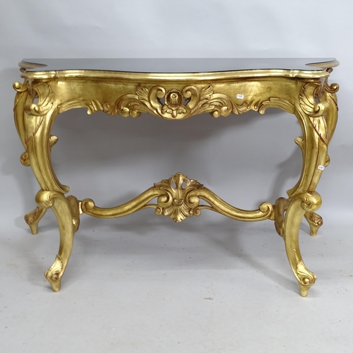 2141 - A gilt painted serpentine console table with black lacquered top. 130cm x 74cm x 57cm