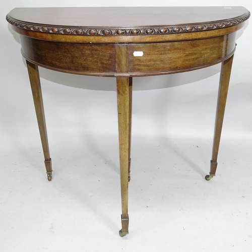 2153 - An early 20th century demilune fold-over card table raised on square tapered legs. 85cm x 78cm x 42c... 