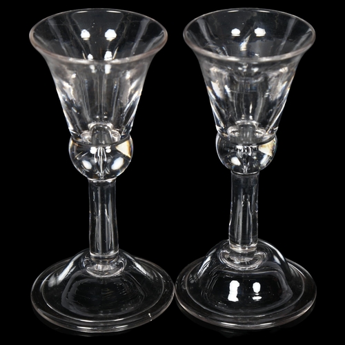 105 - A similar pair of Georgian wine glasses, with bell-shaped bowls on teardrop stems and concave folded... 