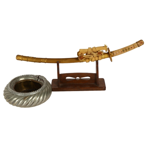 167 - A desk-top study of a Japanese Samurai Tanto, on stand, L36cm, and an African slave bangle made into... 