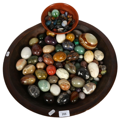 266 - A large quantity of ornamental eggs and various stones, in a hardwood bowl, bowl diameter 49cm.