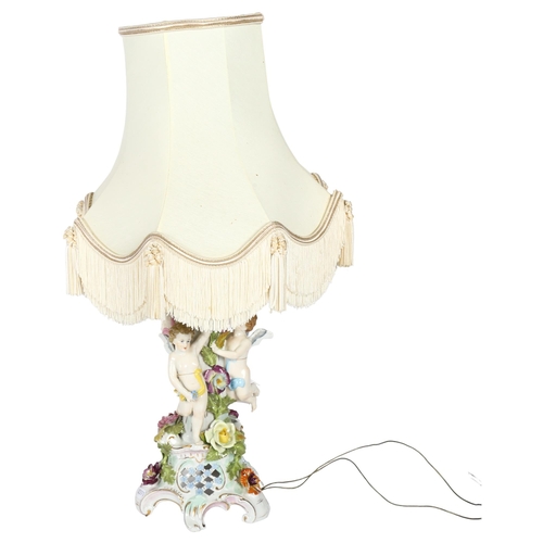 310 - DRESDEN - an ornate Dresden table-top lamp with shade, with cherub and floral design, height includi... 