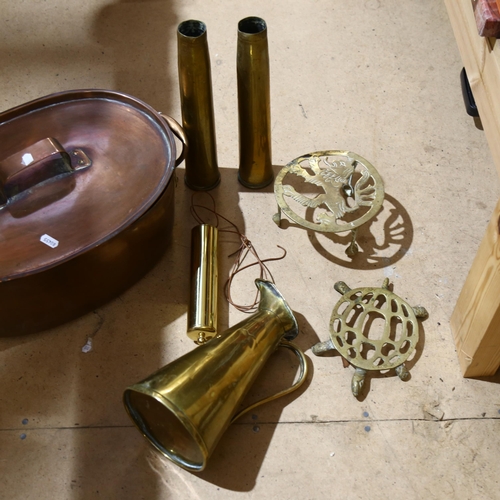 317 - A Victorian copper fish kettle, 2 brass shell casings marked 1944, a brass pot stand with lion decor... 