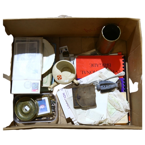 324 - A quantity of military ephemera and artifacts, including a brass shell casing, a military issue trav... 