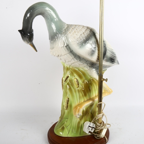 51 - A large Majolica table lamp and shade in the form of a heron amongst the reeds, on a turned wood bas... 