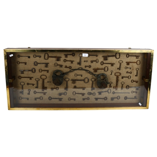 52 - A large wall-hanging display case containing Vintage and Antique skeleton keys, including a set of V... 