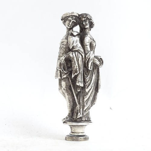 112 - A white metal desk seal depicting Shakespearian characters (lovers). Length 8.5cm