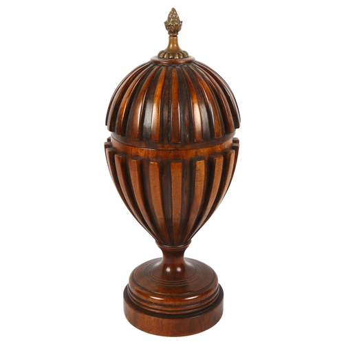 360 - A carved mahogany urn and cover, with fluted design and brass finial, 36cm