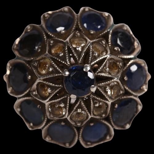 893 - An unmarked yellow metal and silver set dress ring, set with sapphires and paste stones