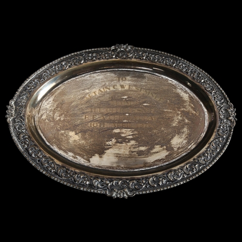 901 - An Elizabeth II oval silver presentation salver, with embossed decoration, presented to Captain C W ... 