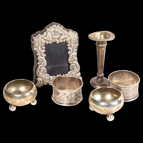 909 - A pair of silver napkin rings, a pair of small silver salts, a small silver-fronted frame, and small... 