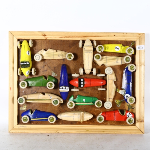 2842 - Clive Fredriksson, a pine-framed group of carvings, racing cars, frame sizes 45cm x 61cm overall