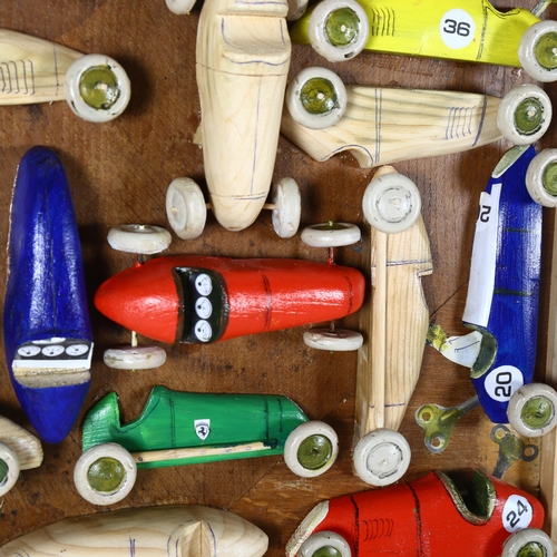 2842 - Clive Fredriksson, a pine-framed group of carvings, racing cars, frame sizes 45cm x 61cm overall