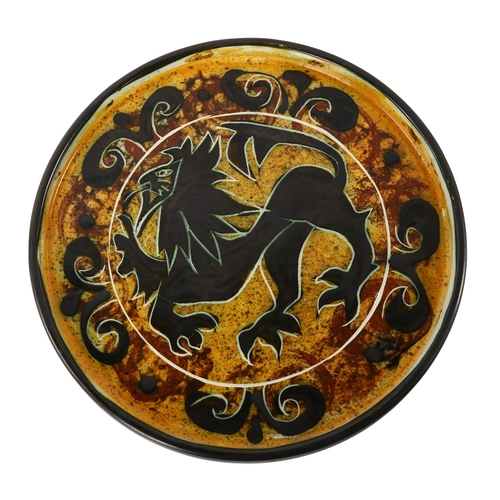 95 - Celtic pottery, Newlyn, Cornwall, a decorative circular dish with stylised lion design, diameter 24c... 