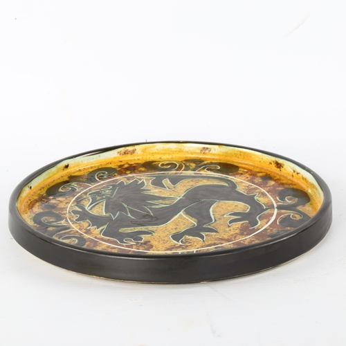 95 - Celtic pottery, Newlyn, Cornwall, a decorative circular dish with stylised lion design, diameter 24c... 