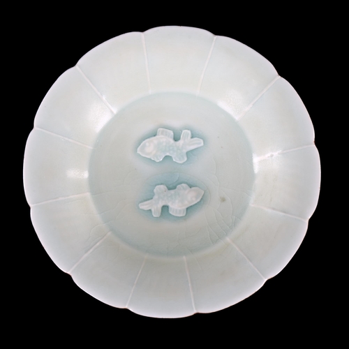 216 - A small Chinese celadon glaze bowl with relief moulded fish design, diameter 15cm