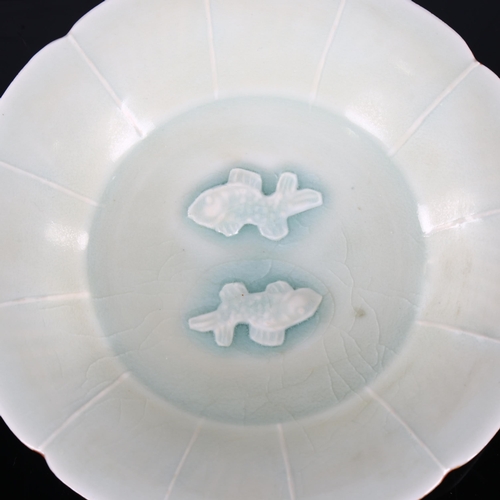 216 - A small Chinese celadon glaze bowl with relief moulded fish design, diameter 15cm