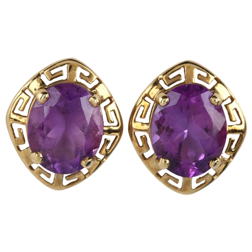 1098 - A pair of amethyst earrings, unmarked gold Greek Key design with oval mixed-cut amethyst, earring he... 