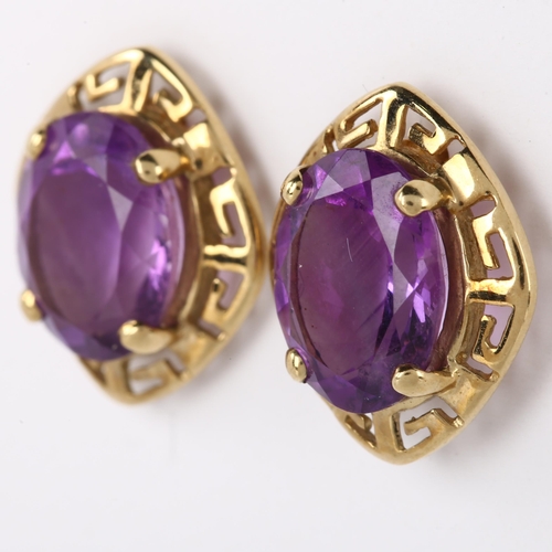 1098 - A pair of amethyst earrings, unmarked gold Greek Key design with oval mixed-cut amethyst, earring he... 