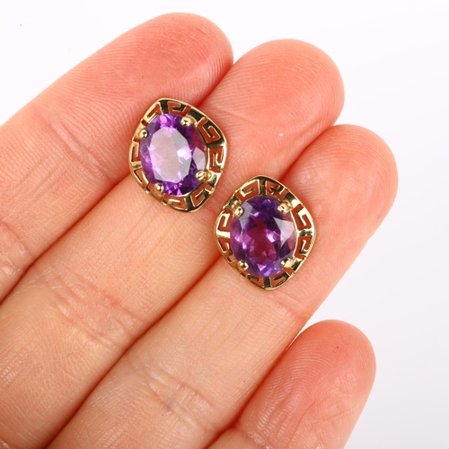 1098 - A pair of amethyst earrings, unmarked gold Greek Key design with oval mixed-cut amethyst, earring he... 