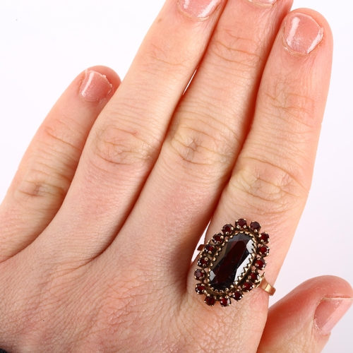 1103 - A 9ct gold garnet cluster ring set with oval and round-cut garnets, setting height 21.2mm, size P, 3... 