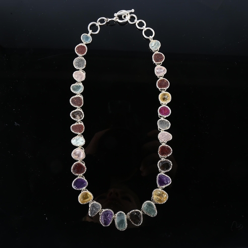 1256 - A silver gem set fringe necklace, set with rough-cut gemstones, including amethyst citrine topaz rub... 