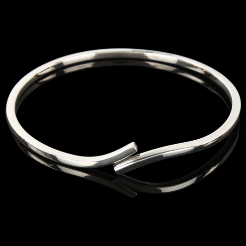 1287 - MICHAEL KARVANY - a Danish sterling silver plain form crossover bangle, band width 2.8mm, internal c... 