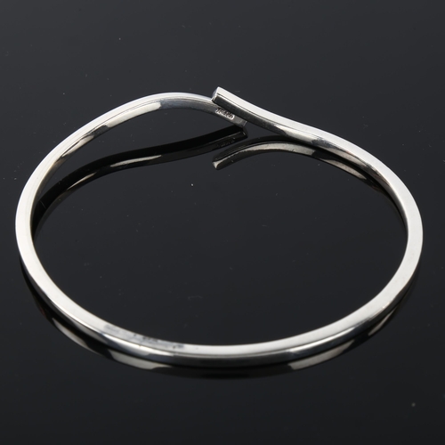 1287 - MICHAEL KARVANY - a Danish sterling silver plain form crossover bangle, band width 2.8mm, internal c... 