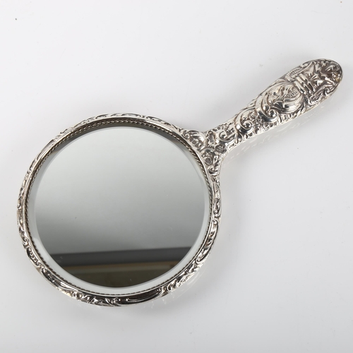 1412 - An Elizabeth II silver filled dressing table hand mirror, allover relief embossed decoration, maker'... 