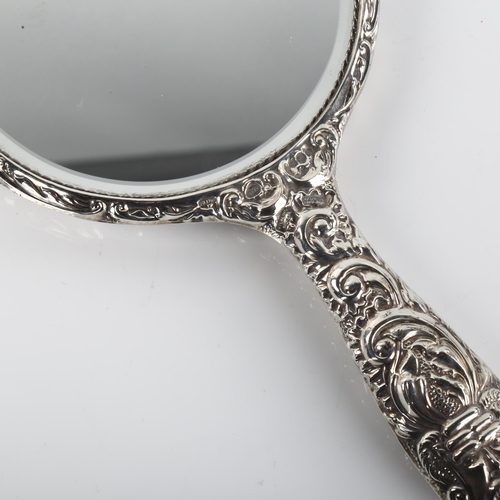 1412 - An Elizabeth II silver filled dressing table hand mirror, allover relief embossed decoration, maker'... 