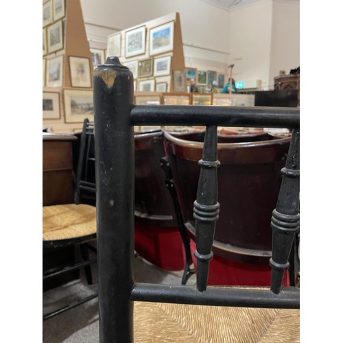 256 - A pair of Morris & Company, Arts and Crafts spindle back ebonised Sussex chairs with rush seats, hei... 